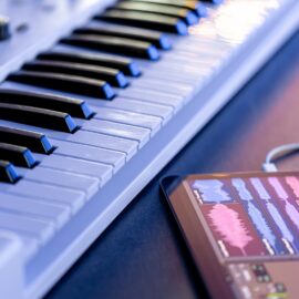 Como escolher o piano digital certo para produção musical e estúdio Chaves musicais e um tablet com uma caneta em cima da mesa