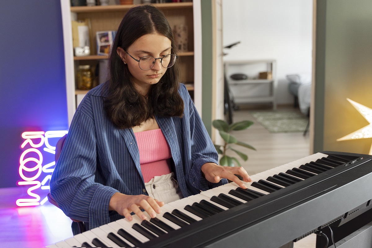 Garota de vista lateral tocando piano em casa Garota de vista lateral tocando piano em casa